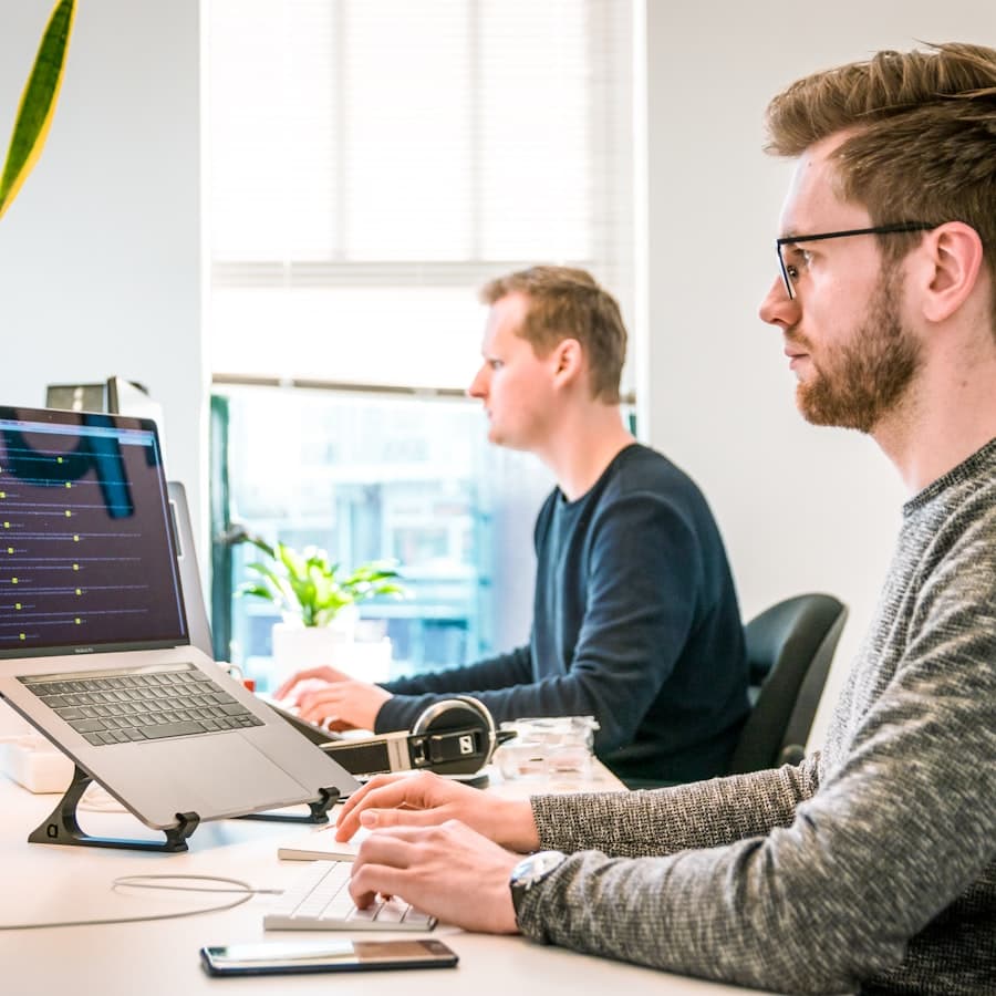 Engineers working at connected workstations on automated systems